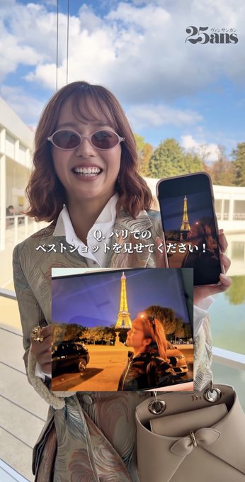 A smiling woman wearing sunglasses and a patterned shirt holds a phone showing a night view of the Eiffel Tower, alongside an inset image of the same tower, with text reading 'Q.パリでのベストショットを見せてください！' and a '25ans' logo.