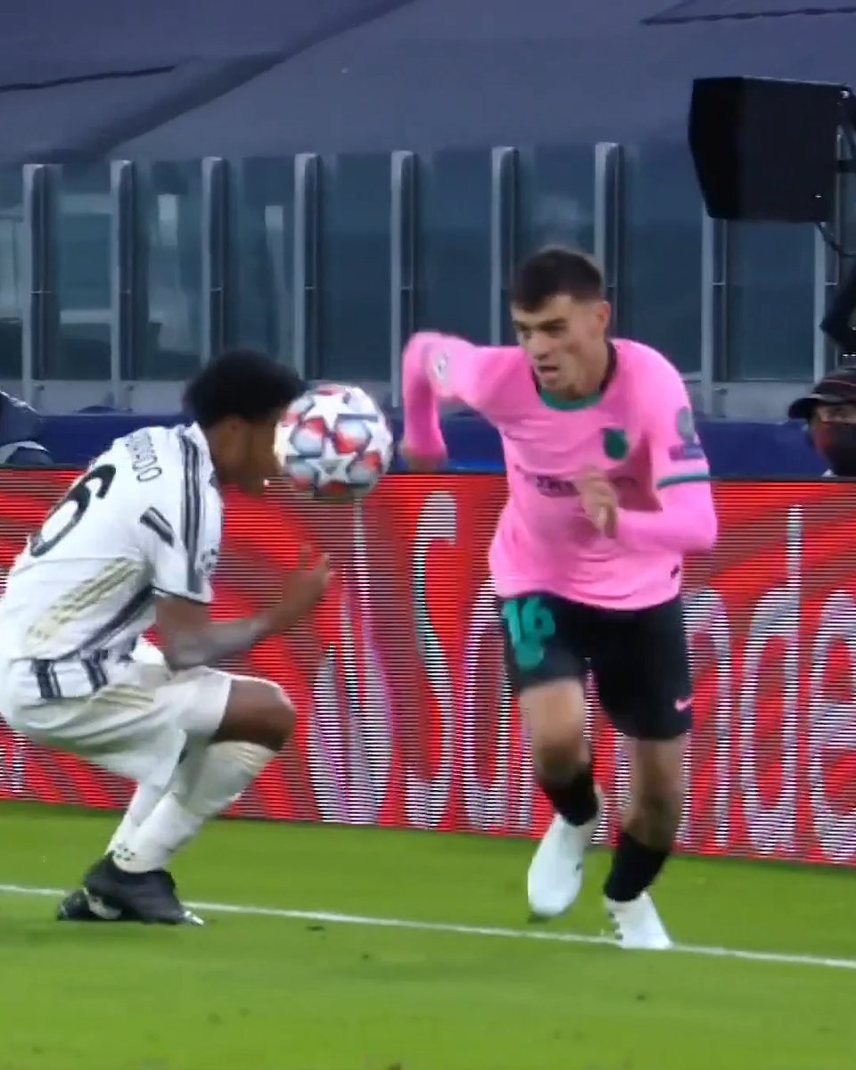 Two soccer players competing for the ball on a field, one in a white Juventus kit and the other in a pink away kit, with a red advertising board in the background.