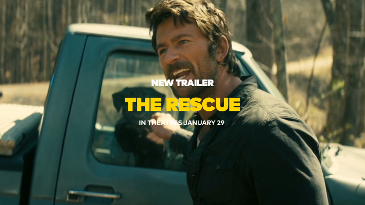 A rugged man with stubble and tousled brown hair stands in front of a dark pickup truck in a wooded setting, smiling slightly. Overlaid text reads "NEW TRAILER," "THE RESCUE," and "IN THEATRES JANUARY 29," promoting the film's mysterious and suspenseful tone suggested by the tagline about hidden secrets in the hills.