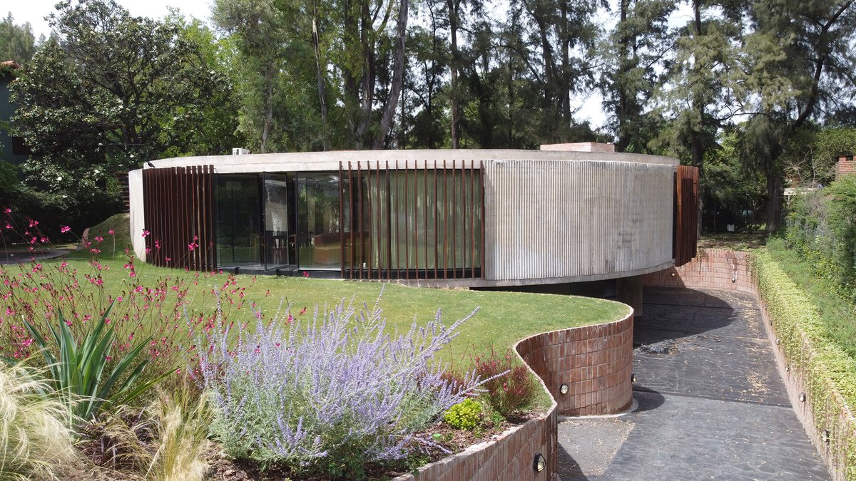 arqcommx's tweet photo. ¿Por qué hacer una casa circular? 
La Casa JB, de Haak Arquitectura, en Buenos Aires, responde al sol y a los árboles existentes. Concreto curvo con encofrado de chapa ondulada, acero y granito negro completan su lenguaje brutalista. https://t.co/5ii1Frx4k1