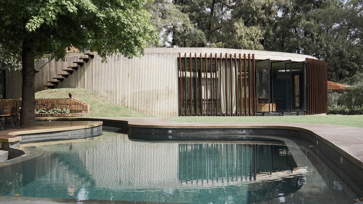 arqcommx's tweet photo. ¿Por qué hacer una casa circular? 
La Casa JB, de Haak Arquitectura, en Buenos Aires, responde al sol y a los árboles existentes. Concreto curvo con encofrado de chapa ondulada, acero y granito negro completan su lenguaje brutalista. https://t.co/5ii1Frx4k1