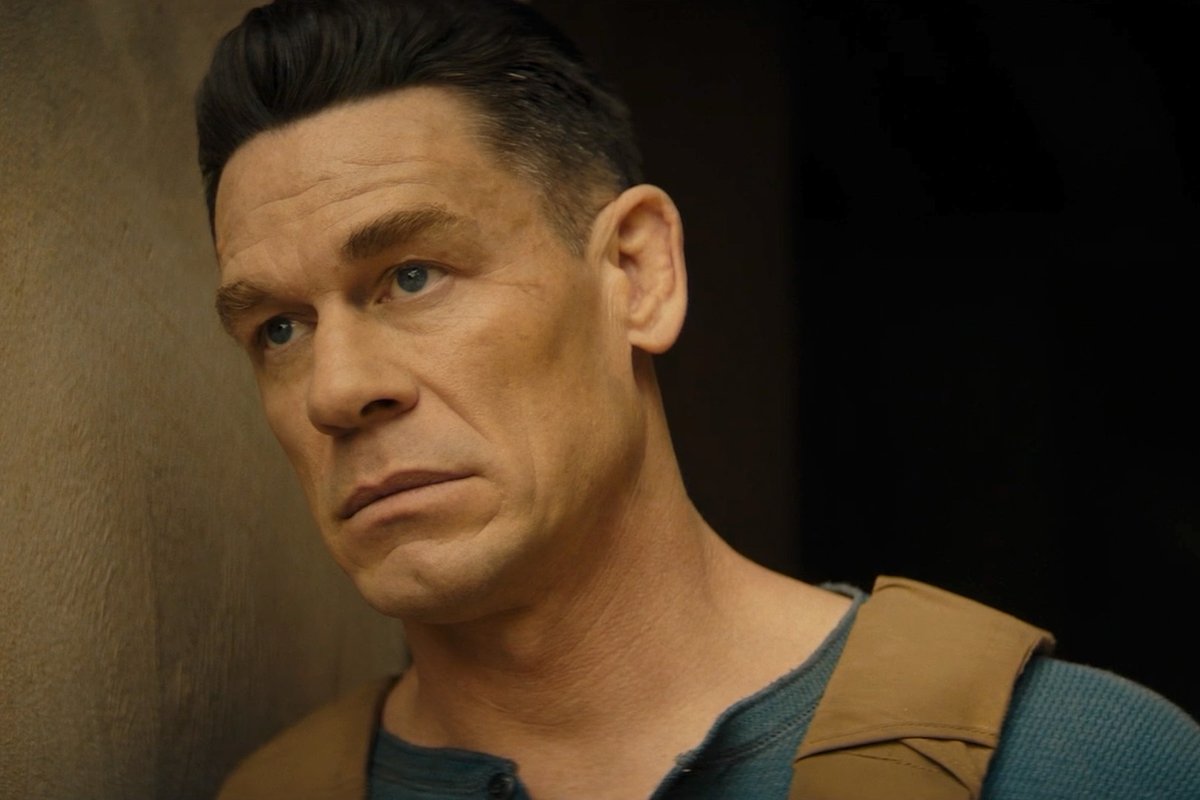 A man with slicked-back dark hair and a serious expression wears a teal henley shirt with tan backpack straps visible on his shoulders, standing against a dim concrete wall in a moody, cinematic close-up that ties into the "10 days to go" countdown post for the film *Matchbox*, set to release on October 9.