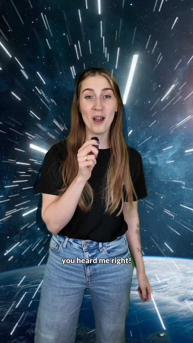 A woman in a black t-shirt and jeans stands before a starry, light-streaked space background, holding a microphone and speaking emphatically with the caption 'you heard me right!' displayed below.