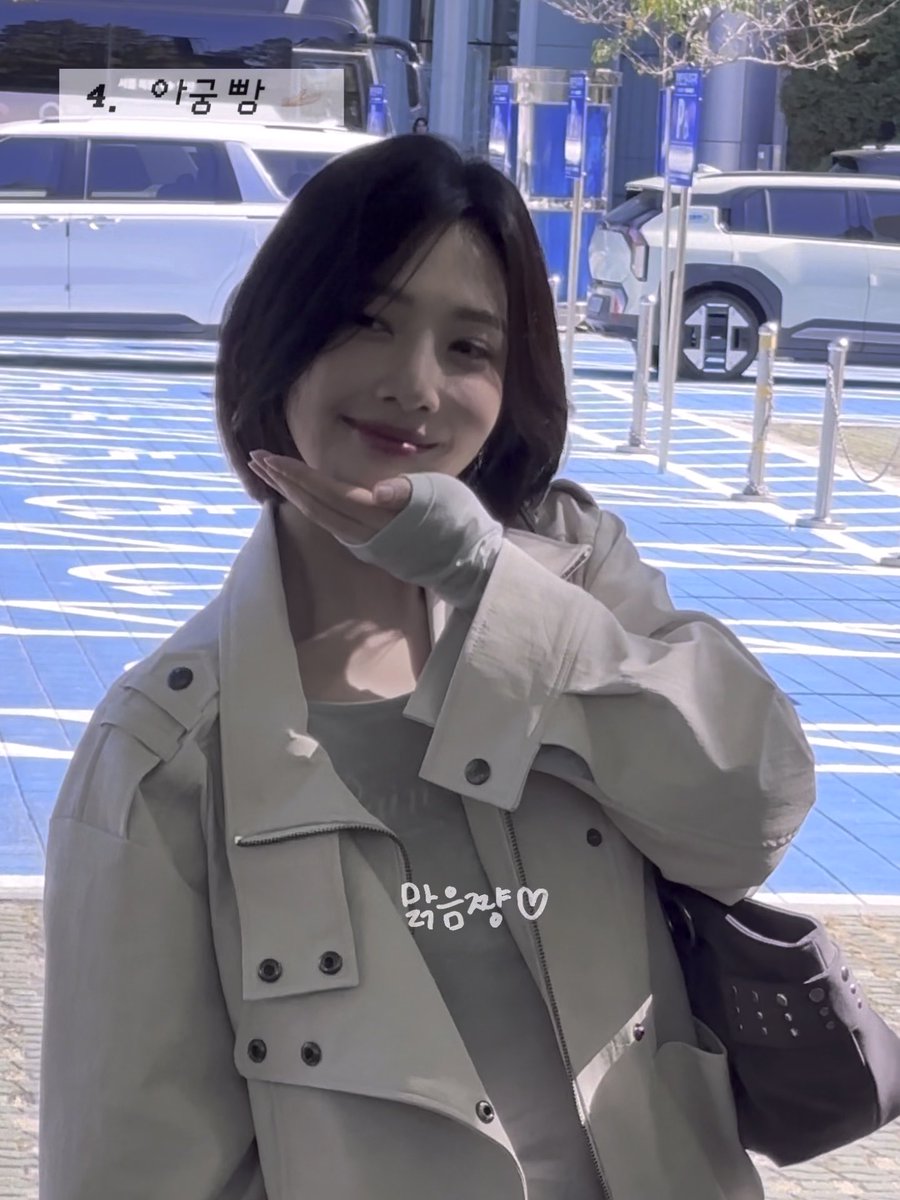 A woman with short brown hair wearing a beige jacket smiles and poses with her hand under her chin in a parking lot, with Korean text '4. 아름빔' and '많음ㅋㅋ♡'.