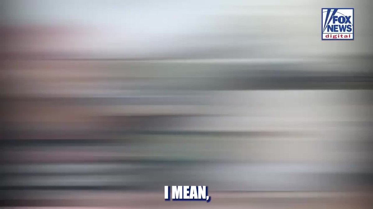 A heavily blurred image from Fox News Digital shows the subtitle "I MEAN," at the bottom of the screen, with the Fox News Digital logo visible in the top right corner. The blurriness suggests the video frame is censored or transitioning, corresponding to the accompanying text about a woman at a Maryland festival responding to a question about government seizing homes.