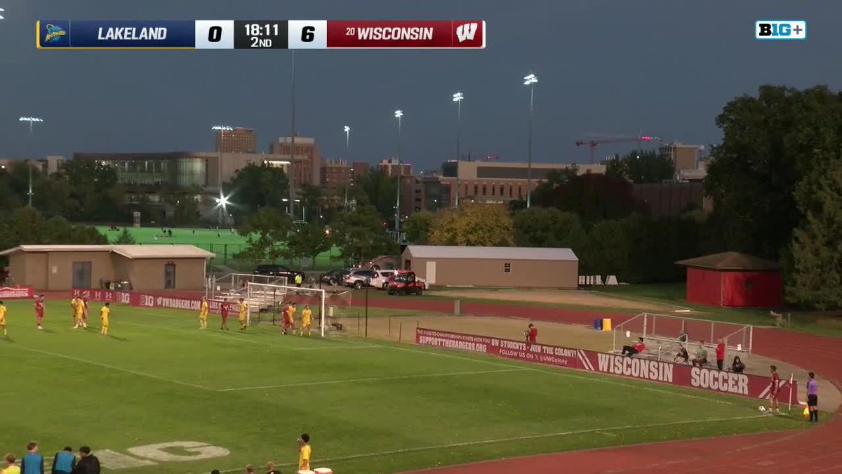 A Big Ten soccer match broadcast showing Lakeland trailing Wisconsin 0-6 at 18:11 in the 2nd half, with "WISCONSIN SOCCER" banners visible along the field.