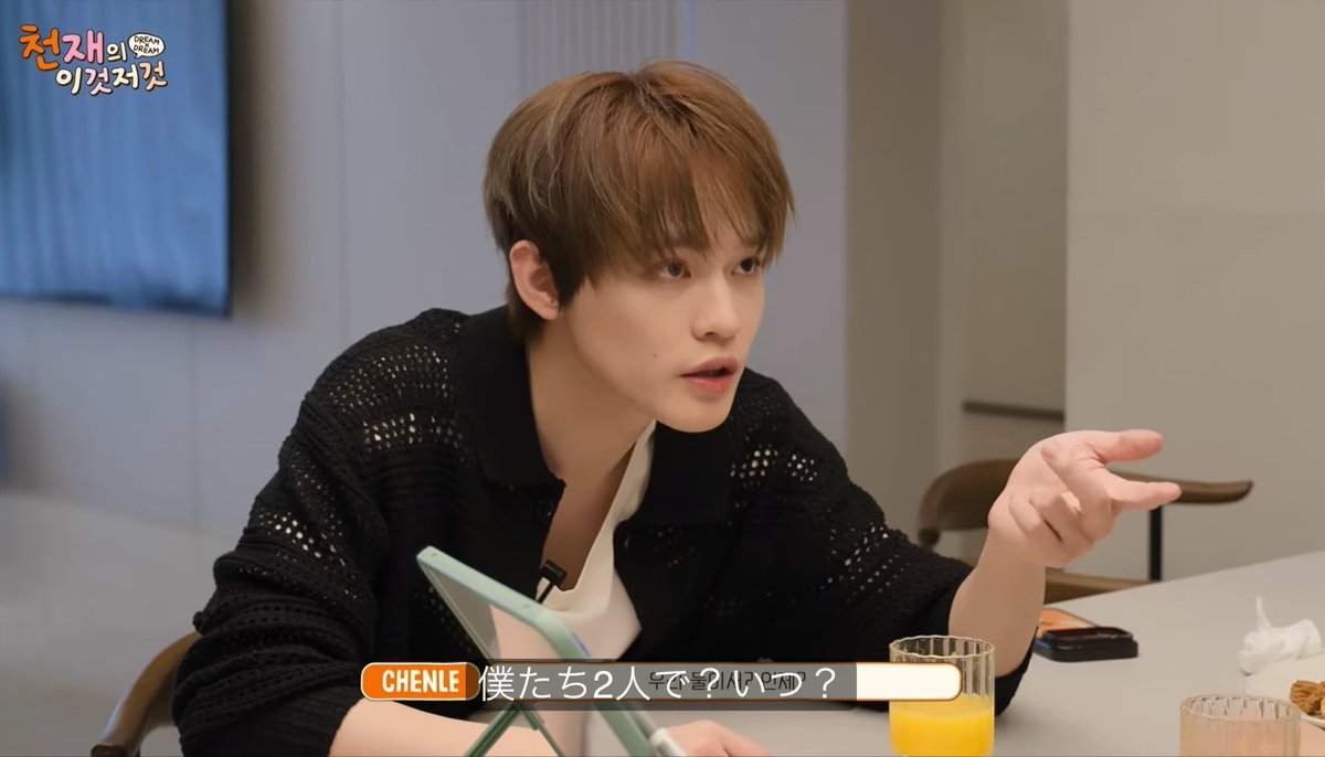 Chenle, a member of the K-pop group NCT, speaks during an interview with Japanese subtitles on screen reading '僕たち2人で' and 'でした〜♪' in a segment titled 'チェンへのDREAM THIS', gesturing while seated at a table with orange juice.