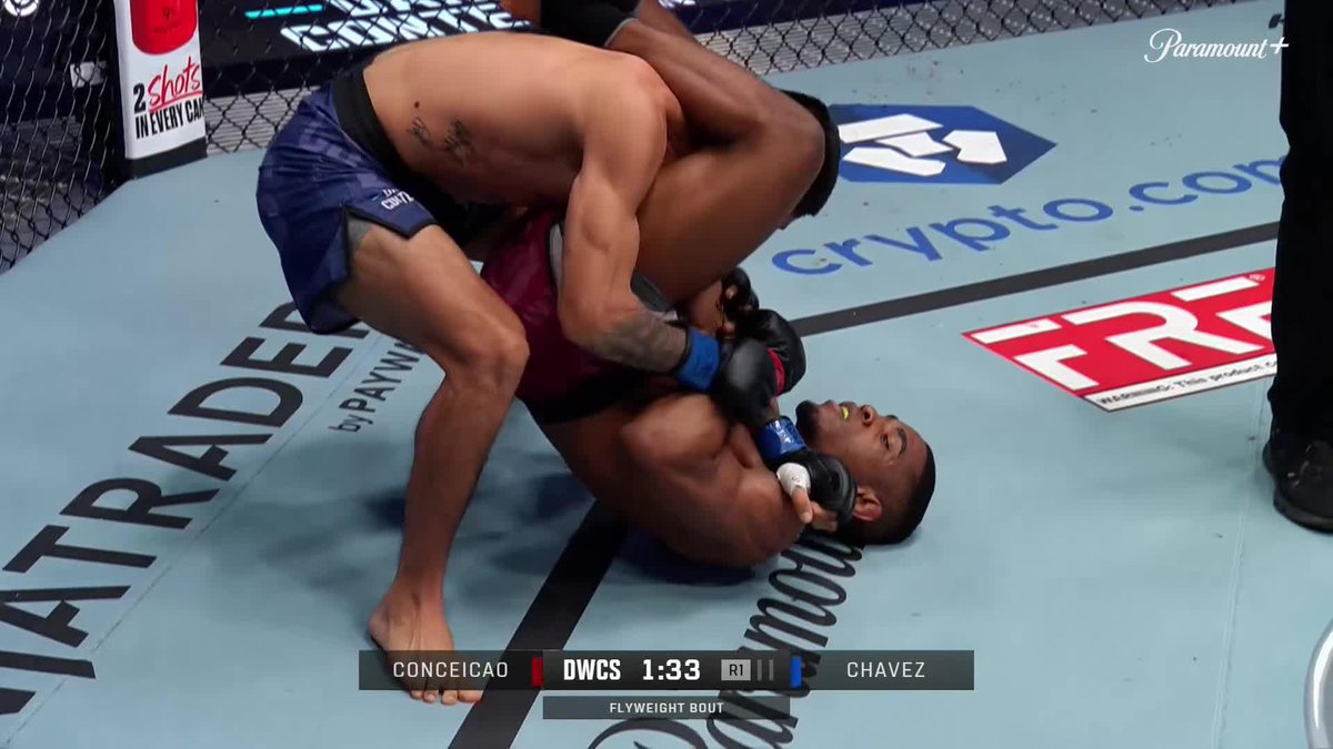 Two fighters grapple on the mat during a UFC DWCS flyweight bout, with the on-screen graphic showing "CONCEICAO vs CHAVEZ" at 1:33 in Round 1, aligning with the post's excitement over a potential submission victory.