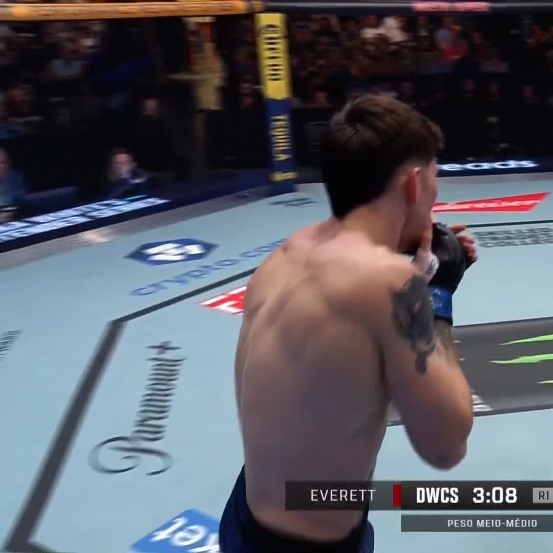 A shirtless fighter stands in the octagon with his gloves raised in celebration as the on-screen graphic displays "EVERETT" and "DWCS 3:08 R1," marking his stunning first-round knockout victory shown live on Paramount Plus BR.