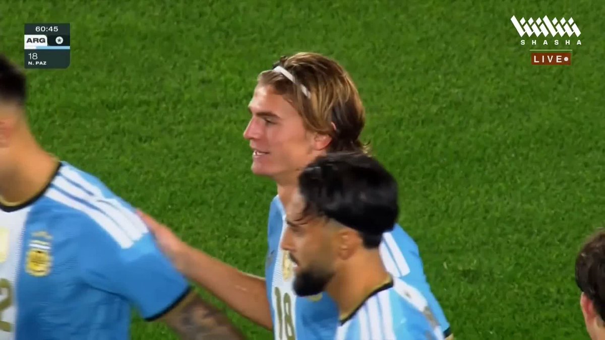 A screenshot from a live soccer broadcast on the 'SHASHA LIVE' channel showing Argentina players in their light blue and white striped jerseys, with an on-screen graphic reading '60:45 ARG 18 N. PAZ'.