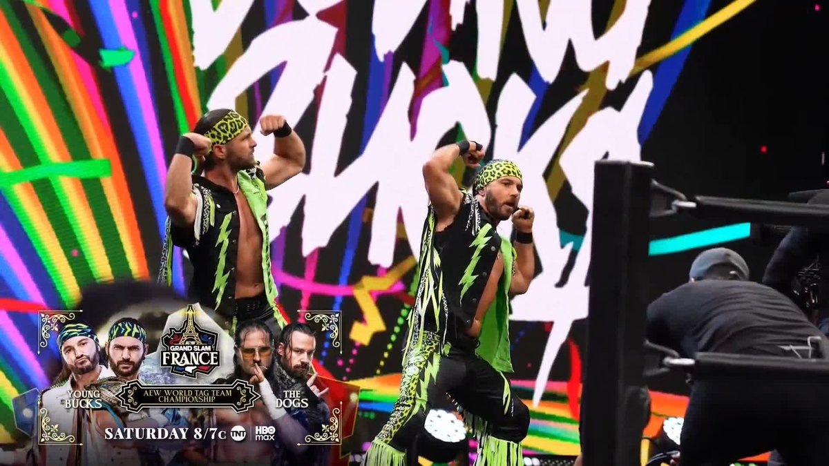 The Young Bucks, wearing matching green and black leopard-print bandanas and vests, pose inside the ring during an AEW event, with a graphic in the corner advertising their AEW World Tag Team Championship match against The Dogs at AEW Grand Slam: France on Saturday at 8/7c on TBS and HBO Max.