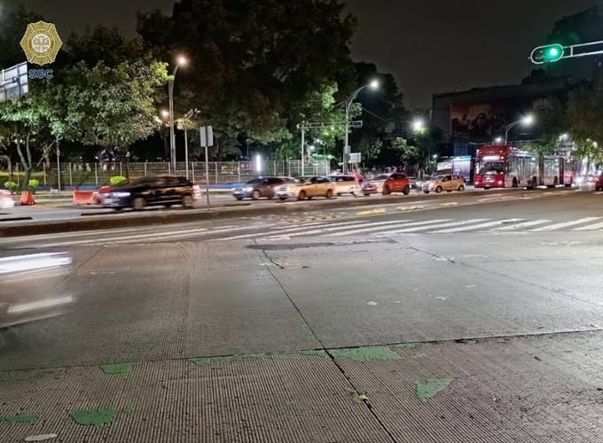 A nighttime scene captures traffic at an intersection on Av. de los Insurgentes, with motion-blurred vehicles crossing through the intersection while a red bus travels in the right lane near the traffic signal. The image documents the urban roadway conditions along Insurgentes from Paseo de la Reforma toward Eje 1 Norte, as indicated by the C5 security camera watermark in the top-left corner.