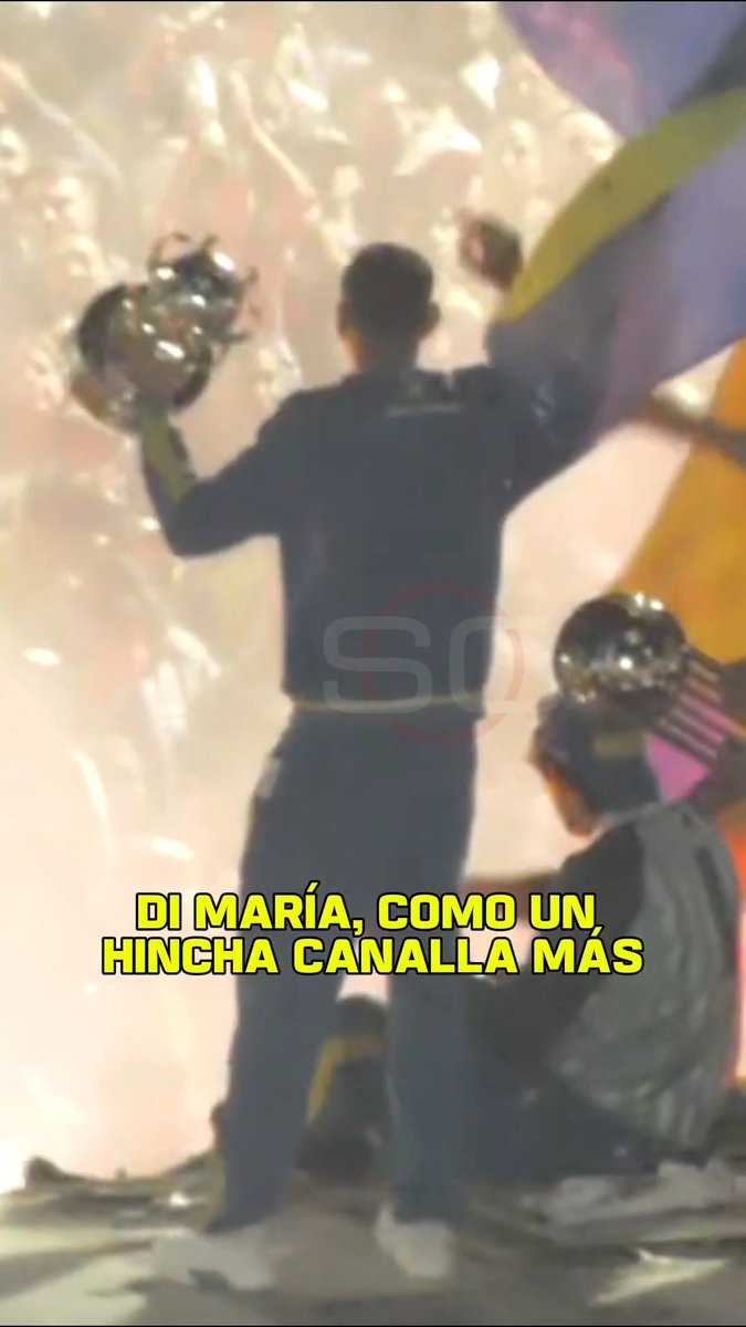 A person celebrating with raised arms holding what appears to be trophies amid bright pyrotechnics, accompanied by Spanish text 'DI MARÍA, COMO UN HINCHA CANALLA MÁS' (Di María, like another Canalla fan), referencing the Rosario Central soccer club.