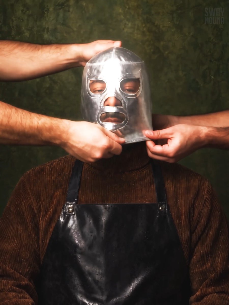 A surreal portrait titled 'SWAY MOLINA' showing a person wearing a metallic lucha libre-style mask with their hands placed in front of their chin, dressed in a brown textured sweater and a dark apron against a mottled green background.