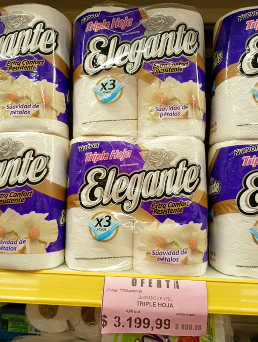 Store shelves display packs of "Elegante Triple Hoja" paper towels with purple packaging, marked "x3 rollos," alongside a pink "OFERTA" price tag showing "$3.199,99" and "$800.00."