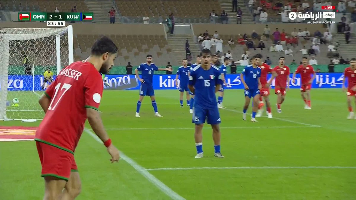 Player Nasser (#17) in red prepares to take a free kick for Oman against Kuwait during a match where Oman leads 2-1 at 83:55, as players from both teams position themselves near the goal. The image captures the tense moment just before the set piece that would lead to Oman's decisive victory, justifying the caption's excitement about Kuwait being "messed up" by this late-game opportunity.