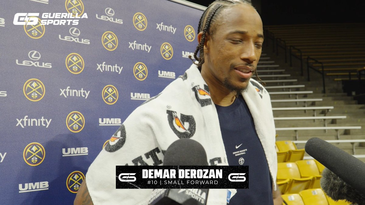 A screenshot from a Denver Nuggets media day featuring DeMar DeRozan (#10, Small Forward) wrapped in a towel while being interviewed, with Guerilla Sports, Lexus, Xfinity, and UMB logos visible on the backdrop.