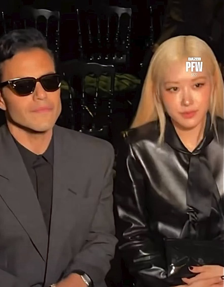 Two people sit next to each other in dark clothing, with the image featuring a 'DAZED PFW SS27' logo in the top right corner.