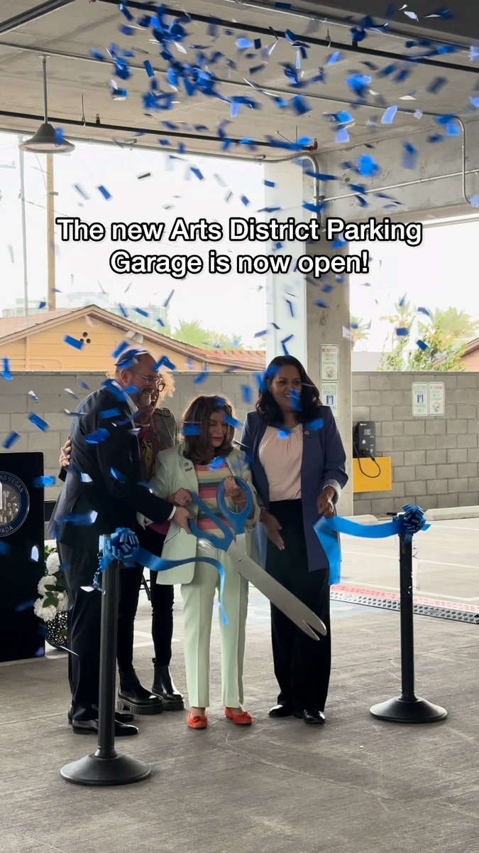 A ribbon-cutting ceremony with people holding oversized scissors under falling blue and white confetti, with text reading 'The new Arts District Parking Garage is now open!'