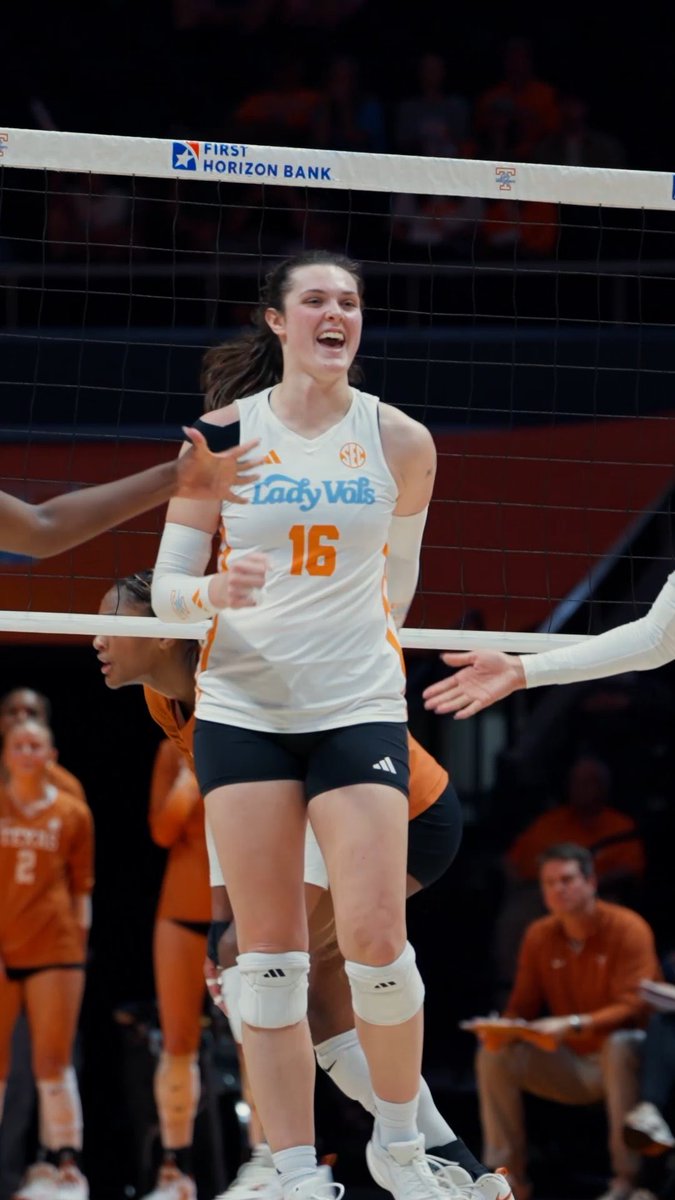 A Tennessee Lady Vols volleyball player wearing jersey #16 celebrates with a triumphant expression at the net during a game, with "FIRST HORIZON BANK" and "SEC" branding visible on the net. The image perfectly captures the "no fly zone" moment as the team, sponsored under #GBO (Go Big Orange), defends their court with fierce energy.