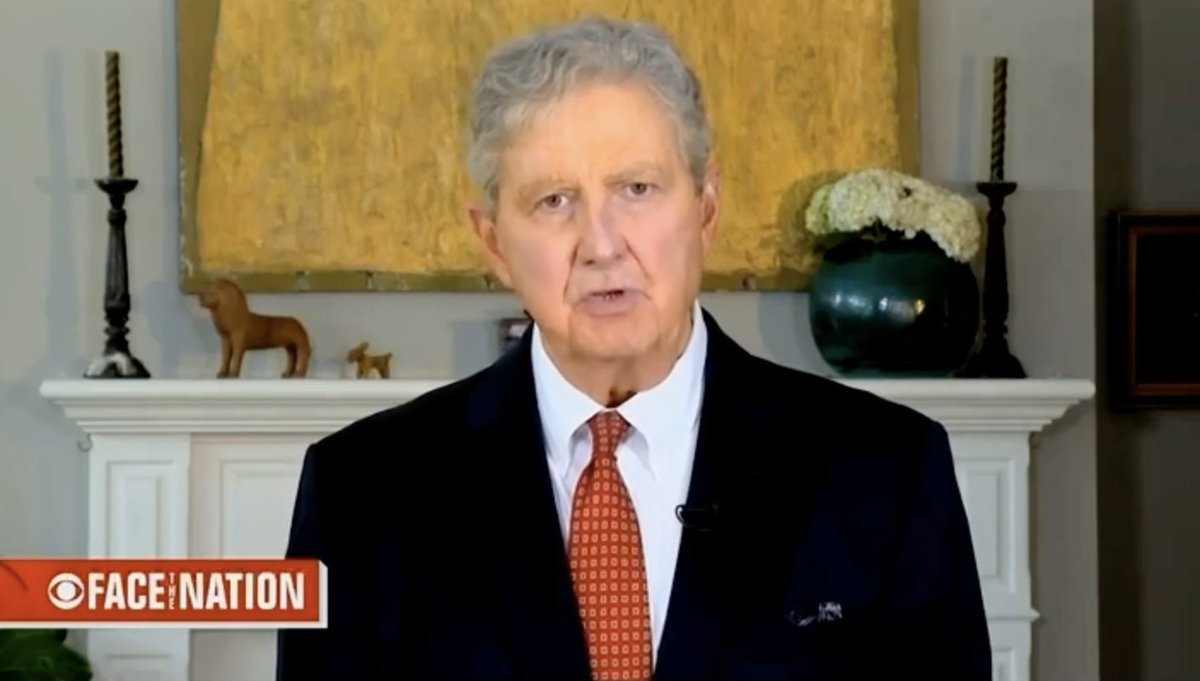 A man in a dark suit and red patterned tie speaks during a CBS "Face the Nation" interview, with a mantel displaying decorative figurines and flowers behind him. The image accompanies a post expressing support for budget-slashing measures championed by the Trump administration.