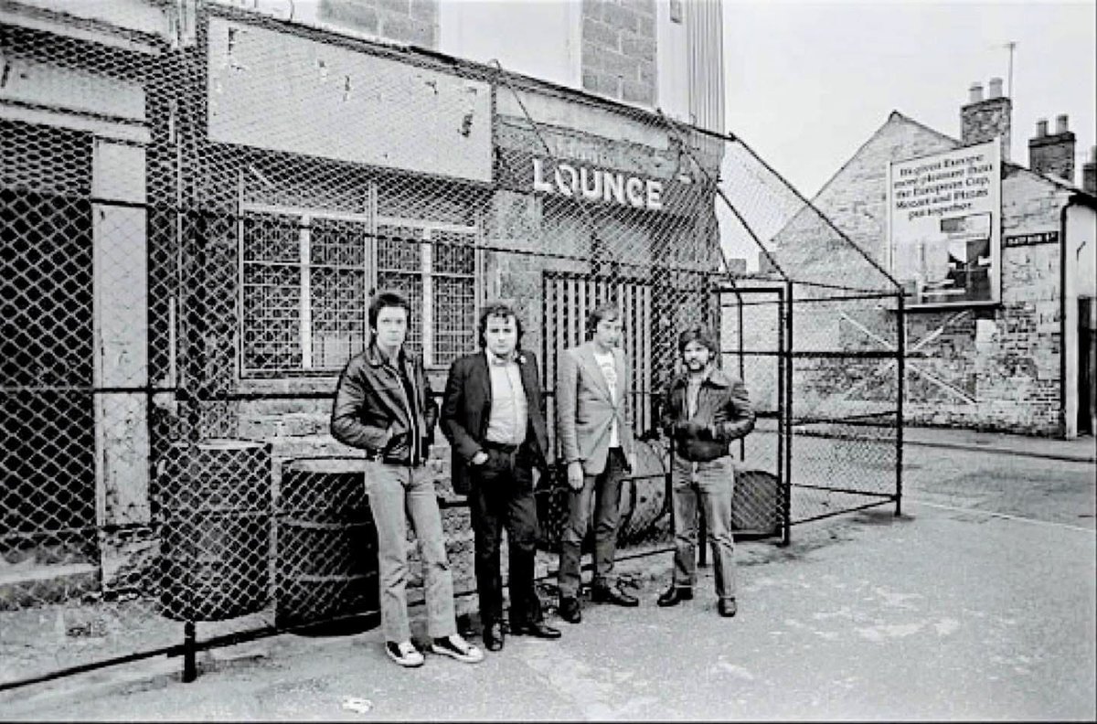 ireland_society's tweet photo. English Band Dr Feelgood outside the Crescent Bar, Sandy Row, Belfast, 1977. Left to right: guitarist Gypie Mayo, drummer John 'The Big Figure' Martin, singer Lee Brilleaux  and bassist John B. Sparks. (Wilko had left the band earlier that year. (©️Chalkie Davis) https://t.co/IHGQaoT0Oo