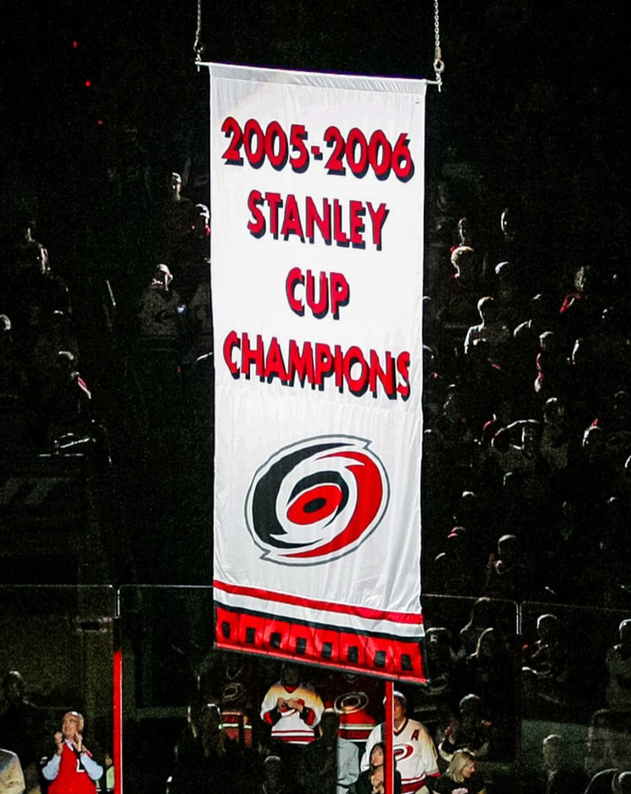 sportslogosnet's tweet photo. The Carolina Hurricanes raised their 2026 Stanley Cup banner and, in doing so, revealed a new championship banner design for the club. The 2006 banner has been updated to match.

See the new and the old designs in the pics here, which is better? https://t.co/KcuPrikELT