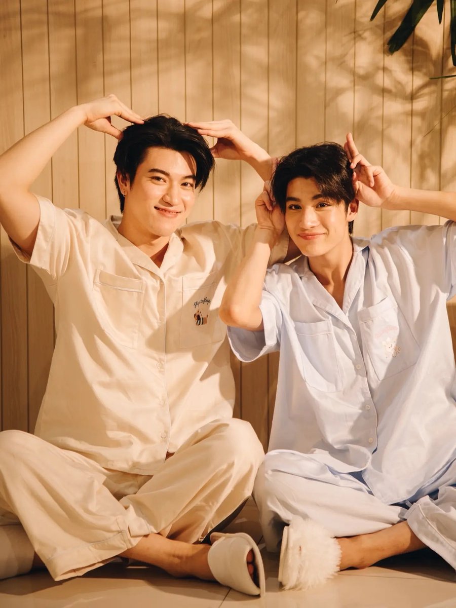 enfer_les's tweet photo. AU อรุณรุ่ง | ฟิคหาซ้อใหม่ให้เฮีย 
ตอนที่ 2
#อรุณรุ่ง_fanfiction

หลังจากแต่งงานกันตามคำขอของคุณป๋า ชีวิตคู่ของเฮียกับคุณธัชก็ไม่ได้เปลี่ยนไปมากนัก เฮียยังทำงานตั้งแต่เช้าจนดึก กลับบ้านมาก็เอาแต่คุยเรื่องงาน กินข้าวเงียบ ๆ แล้วขึ้นห้องไปนอน ความสัมพันธ์ของทั้งคู่เป็นเพียงคู่แต่งงานตามชื่อในทะเบียน ไม่มีใครคาดหวังความรักจากอีกฝ่าย

ยกเว้นคุณธัช...เพราะต่อให้เฮียไม่เคยรักเขา คุณธัชก็รักเฮียมาตลอด 

คืนนี้ก็เหมือนทุกคืน คุณธัชนั่งเท้าคางอยู่ในครัวคนเดียวในชุดนอนตัวใหม่ที่เพิ่งซื้อมา เป็นชุดคู่ที่อีกตัวแขวนรออยู่ในห้อง เขาเหลือบมองนาฬิกา ก่อนถอนหายใจ

“กลับดึกอีกแล้ว...”

เสียงประตูบ้านเปิดขึ้นในที่สุด เฮียเดินเข้ามาพร้อมแฟ้มงานในมือ สีหน้าเหนื่อยล้าเหมือนคนที่เพิ่งผ่านวันอันวุ่นวายมา คุณธัชหันไปมองทันที

“เฮีย กินข้าวไหม”

“ไม่ล่ะ เฮียกินมาแล้ว”

“อือ”

คุณธัชตอบสั้น ๆ แล้วก้มมองถ้วยตรงหน้า ทำเหมือนไม่ได้รู้สึกอะไร เฮียกำลังจะเดินผ่านไป แต่สายตากลับเหลือบเห็นชุดนอนที่คุณธัชใส่อยู่

“ชุดอะไร”

“ชุดนอน”

“รู้แล้วว่าเป็นชุดนอน”

“ก็...ชุดคู่”

เฮียเงียบ

คุณธัชรีบพูดต่อเหมือนกลัวอีกฝ่ายจะคิดมาก

“ผมเห็นมันน่ารักดี เลยซื้อมา ไม่ได้จะให้เฮียใส่หรอก”

“อืม”

แค่คำเดียวก็ทำเอาคุณธัชยิ้มแห้ง

“เฮียไปพักเถอะ”

เฮียเดินขึ้นไปได้สองสามขั้น ก่อนหยุด

“ตัวของเฮียอยู่ไหน”

คุณธัชเงยหน้าขึ้นทันที

“ในห้อง...ทำไม”

“เอามาให้เฮีย”

“เฮียจะใส่?”

“ก็ไหน ๆ ซื้อมาแล้ว”

ไม่ถึงสิบนาทีต่อมา เฮียก็กลับลงมาในชุดนอนตัวเดียวกัน เพียงแต่สีหน้าบอกชัดว่าเจ้าตัวไม่ได้เข้าใจเลยว่าทำไมตัวเองถึงยอมใส่

คุณธัชหลุดยิ้ม

“ขำอะไร”

“เปล่า”

ทั้งคู่นั่งลงตรงโต๊ะครัวด้วยกันเป็นครั้งแรกในรอบหลายวัน ความเงียบอยู่พักใหญ่ ก่อนเฮียจะเป็นฝ่ายพูดขึ้น

“คุณธัช”

“ครับ”

“เฮียรู้ว่าคุณเหงา”

รอยยิ้มของคุณธัชค่อย ๆ จางลง

“ไม่เป็นไร ผมชินแล้ว”

“เฮียไม่ได้ตั้งใจจะละเลยคุณ”

“ผมรู้”

“แต่เฮียอาจจะยังไม่เก่งเรื่องเป็นสามี”

คุณธัชเงียบไปครู่หนึ่ง ก่อนยิ้มบาง ๆ

“ผมก็ไม่ได้เก่งเรื่องเป็นสามีเหมือนกัน”

เฮียมองเขา ก่อนหัวเราะเบา ๆ เป็นเสียงหัวเราะที่คุณธัชไม่ค่อยได้ยินนัก

“งั้นค่อย ๆ เรียนไปด้วยกัน”

แค่นั้นก็เพียงพอให้คนที่แอบรักมานานยิ้มออกมาได้อีกครั้ง

คุณธัชขยับเข้าไปใกล้ แล้วมองชุดนอนของเฮีย

“เฮีย”

“หืม”

“ทำหูหมาให้ผมหน่อย”

เฮียขมวดคิ้ว “อะไร”

“นี่ไง”

คุณธัชยกมือขึ้นทำเป็นหูหมา แล้วหัวเราะ

“แบบนี้”

เฮียมองอยู่พักหนึ่ง ก่อนจะยกมือขึ้นทำตามอย่างเก้ ๆ กัง ๆ

“แบบนี้?”

คุณธัชหลุดหัวเราะทันที

“ใช่ ๆ แบบนั้นแหละ”

เฮียมองเขาอย่างไม่เข้าใจ แต่ก็ยังทำหูหมาค้างไว้ ส่วนคุณธัชได้แต่มองภาพตรงหน้าแล้วยิ้ม

ไม่รู้ว่าเมื่อไหร่เฮียจะรักเขา

แต่คืนนี้ อย่างน้อยเฮียก็ยอมใส่ชุดนอนคู่กับเขาแล้วหนึ่งครั้ง สำหรับคนที่รอมานานอย่างเขา แค่นี้ก็มากพอแล้ว
