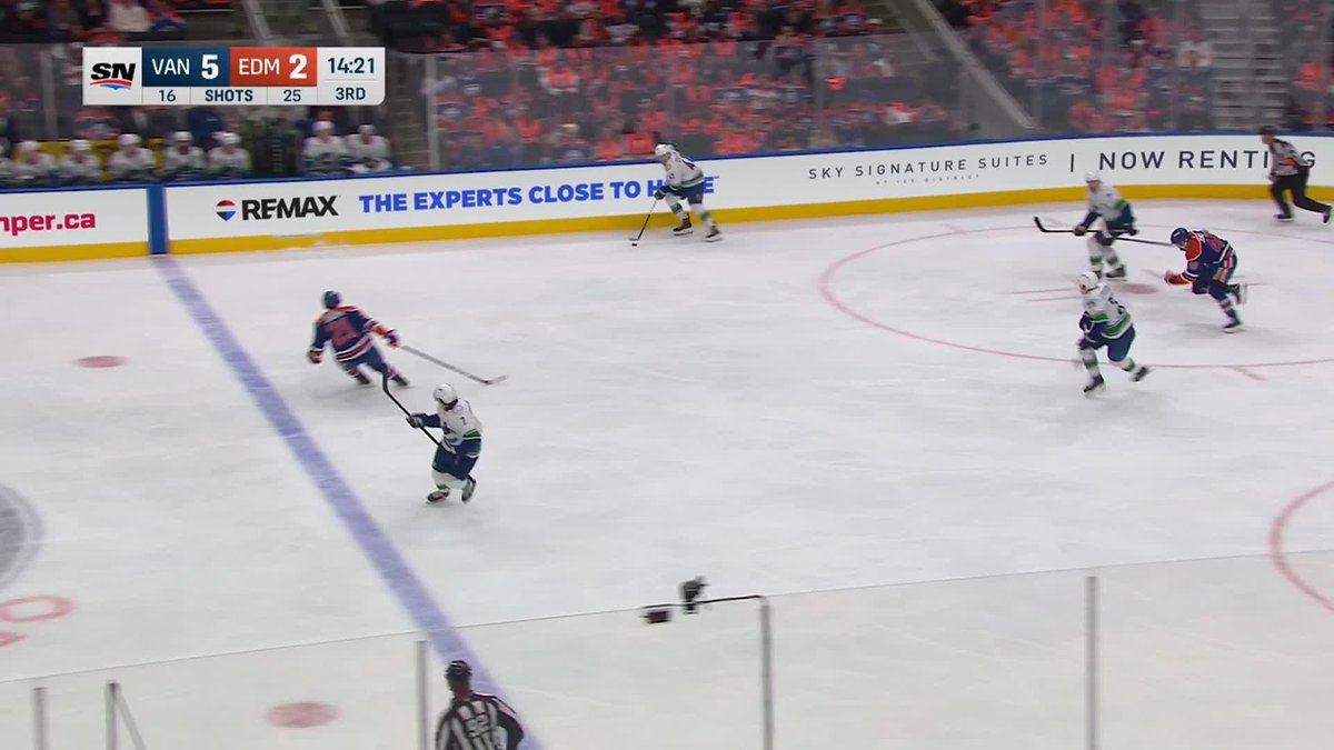 During a power play in the 3rd period, the Vancouver Canucks (VAN) lead the Edmonton Oilers (EDM) 5-2 with 14:21 remaining, as shown on the SN scorebug. Canucks player "Petey" (Pettersson) skates with the puck in the offensive zone, setting up the play that led to Vancouver's fifth goal.