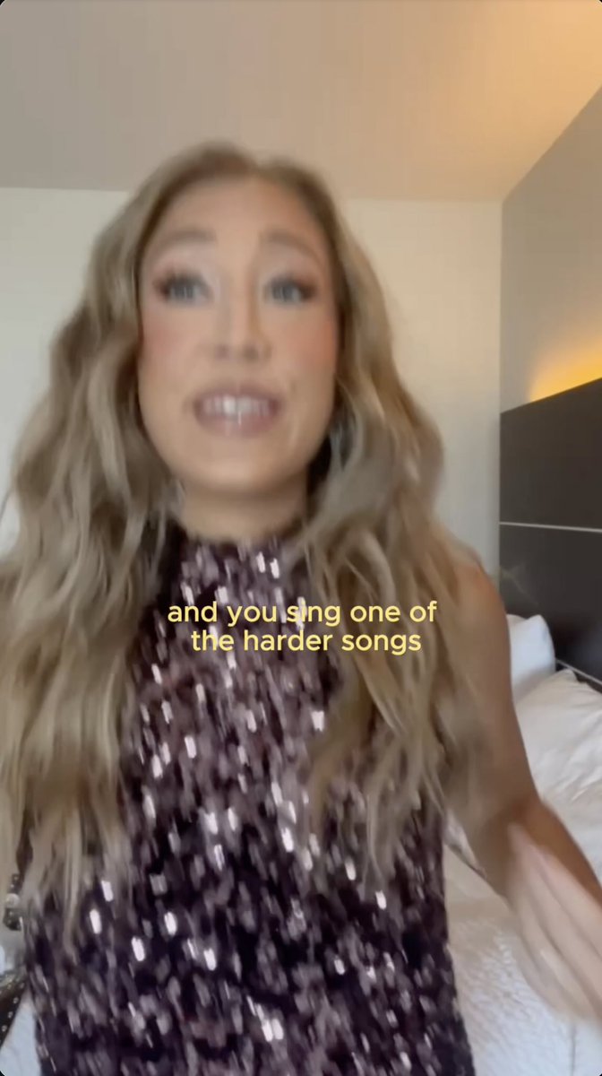 A woman with long blonde hair in a sparkly purple top speaks to the camera with the caption 'and you sing one of the harder songs'.
