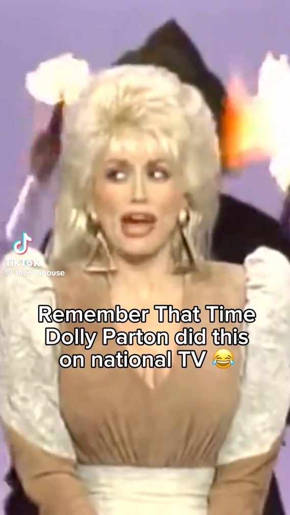 A TikTok video screenshot from '@the61sthouse' showing Dolly Parton in a blonde wig and white dress with the caption 'Remember That Time Dolly Parton did this on national TV 😂'.