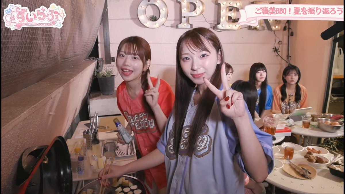 A still from a Japanese variety show featuring "すぃ～ず" (Sweeze) where several young women in casual clothes pose at a BBQ gathering under a marquee-style "OPEN" sign.