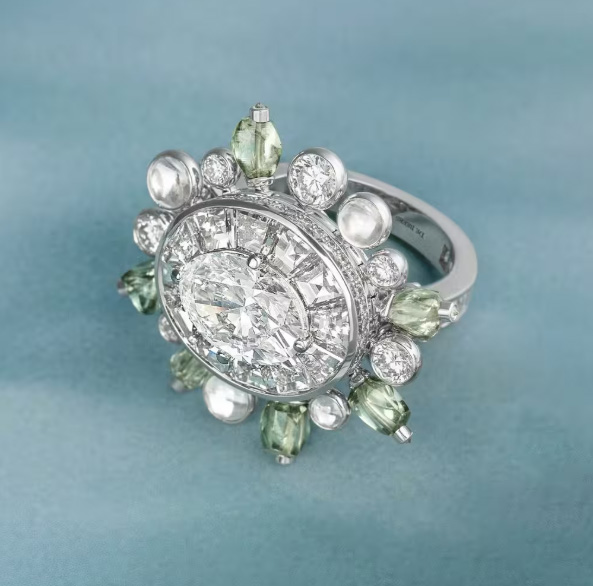 JewelConcierge's tweet photo. デビアス、ダイヤモンドに稀少なカボションカットを採用

デビアス・ロンドンは、ダイヤモンドのカットの中でも極めて珍しい「カボション」を独自にアレンジし、水滴を思わせる滑らかで丸みを帯びたダイヤモンドを開発した。
ファセットを持たないこの形状は、光が滑らかな表面から反射することで、従来のブリリアントカットとは異なる柔らかく透明感のある輝きを生み出す。
ファセットで内包物を隠すことができないため、石そのものの品質がより厳しく問われる。

同社が5年をかけて開発した技術によると、この加工に適した色・透明度・結晶構造・対称性などの条件を満たすダイヤモンドは全体の0.5%にも満たないという。
新しいカットは、ハイジュエリーコレクション「Vibrations」で発表される。

カボションはファセットを持たない伝統的な宝石カット技法で、通常はサファイアやルビー、エメラルドなど有色石に用いられることが多い。
一般的なカボションは、丸く研磨された頂部と平らな底面を持つ楕円形が典型的だが、デビアスのバージョンはファセットを持たないという基本構造を保ちつつ、意図的に水滴のような丸みを帯びたフォルムに仕上げている点が特徴である。
ダイヤモンドは非常に硬い素材であるため、カボションカットが施されることは稀で、米国宝石学会(GIA)もこれまでに天然ダイヤモンドのカボション(約6.29カラットと6.07カラットの2石を含む)を確認しているが、カラーストンに比べて極めて珍しい試みだとしている。

ファセットがないことで内部の特徴がより露わになるため、卓越した品質と純度、適切な結晶構造や対称性が不可欠になるという。
完成した石は、多数の角度をつけたファセットが生む鋭いきらめきとは対照的に、深みのある柔らかな輝きを放つとされる。

このカボションは、ボツワナのオカバンゴ・デルタに着想を得た「Undulation」に採用されており、川辺に浮かぶ水滴のような丸みを表現することを意図している。

IDEX:　https://t.co/YtZm22v5yM