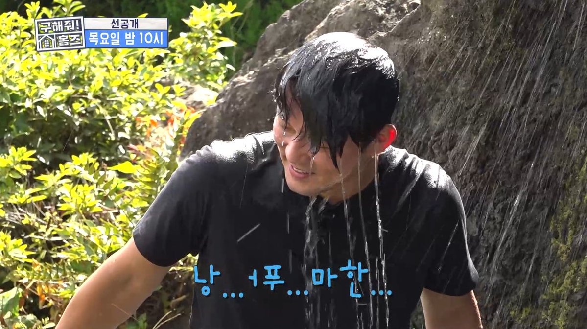 A screenshot from a Korean variety show showing a young man in a black t-shirt standing in a waterfall with a strained expression, accompanied by Korean text and the subtitle '냉... 너무 망한...' (Cold... so ruined...).