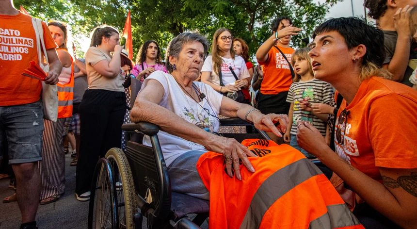 donocooperativa's tweet photo. ☢️ Reflexão da Cooperativa:  María del Carmen Abascal Martín, Maricarmen para os amigos. Já todos sabemos quem é. Uma velha carcaça. Doravante, vamos chamar-lhe só velha, ou cota, já vemos.

Eu olho para esta caso da velha e acho que o despejo é a parte menos preocupante disto tudo.

É.  A velha já soprou 87 velas. Não teve filhos, não adotou e chega ao fim da vida sem descendentes diretos.  Aos 87 anos, o corpo já negoceia connosco coisas que aos 40 dávamos por garantidas e a cota está essencialmente sozinha e abandonada ao seu próprio destino.

⚠️E para mim é esta a história que a Espanha devia estar a discutir.

Nos últimos dias milhares de pessoas preocupadas com a velha. Políticos e deputados indignados, jornalistas a gastarem a tinta toda da caneta, manifestantes ali, nas ruas, solidários com a velha. Agora é uma avó nacional de todos os espanhóis.

A velha é útil, mas ninguém quer saber dela.

Serve para colocar num cartaz. A vítima perfeita para uma discussão inquinada sobre habitação, fundos imobiliários, capitalismo, senhorios e rendas. Cada um podia pegar num pedaço da velha e levá-lo para casa para confirmar aquilo em que já acreditava. De repente já nem é bem um cota de 87, é um argumento.

⚠️Somos extraordinariamente bons a preocupar-nos com pessoas quando elas se transformam em causas e cada vez menos competentes a preocupar-nos com pessoas simplesmente porque são pessoas.

É por isso que a pergunta que esta história me provoca não é apenas onde vai viver a velha. É quem vai estar com a velja quando tiver 90 anos. Quem lhe vai telefonar ao domingo à noite quando já não houver jornalistas à porta. Quem lhe vai perceber pela voz que alguma coisa não está bem. Quem vai reparar que não abriu as persianas. Quem vai insistir para que vá ao médico. Quem vai ouvir pela décima vez uma história que já conhece. Quem vai simplesmente entrar em casa e perguntar se quer companhia. Ninguém. Quando derem pela falta da velha, é porque o cheiro já não se aguenta.

Nas últimas décadas fizemos uma transformação social gigantesca e achamos que era apenas isto do progresso. Libertámos o indivíduo de uma quantidade enorme de obrigações antigas e, em muitos casos, fizemos muito bem. Tornámo-nos mais livres para escolher onde viver, com quem viver, se queremos casar, se queremos ter filhos, se queremos sair da terra onde nascemos, se queremos dedicar a vida a uma carreira, viajar ou simplesmente não prestar contas a ninguém. Há uma extraordinária conquista humana nessa liberdade, é um facto, mas talvez tenhamos confundido liberdade com ausência de dependência.

Não são a mesma coisa.

O ser humano pode passar metade da vida a conquistar independência e a segunda metade a descobrir que nunca deixou verdadeiramente de precisar dos outros. Adiou o momento em que isso se torna evidente.

⚠️Aos 30 anos é fácil imaginar que não devemos nada a ninguém. Aos 40 ainda é bastante confortável. Aos 50 começamos a enterrar os pais. Aos 60 começam a desaparecer amigos. Aos 70 o mundo que conhecíamos começa lentamente a ficar mais pequeno. E aos 87 já não há filosofia individualista que consiga mudar uma lâmpada quando não conseguimos subir a um escadote.

Há uma parte profundamente incómoda nisto porque obriga a recuperar uma palavra que a modernidade quase transformou numa obscenidade moral. Responsabilidade. Não responsabilidade coletiva, essa é facílima. Responsabilidade pessoal.

A velha também fez as suas escolhas. Eu fiz as minhas. Tu fizeste as tuas. Continuamos todos a fazê-las.

Isso não significa que uma pessoa sem filhos mereça a solidão. Eu sei que há pais abandonados pelos próprios filhos e há pessoas que nunca tiveram descendentes e chegam aos 90 rodeadas de amigos, sobrinhos, afilhados e gente que construíram pelo caminho. Uma criança também não deve nascer com a missão de se transformar no enfermeiro dos pais 50 anos depois.

Mas também seria infantil fingirmos que as escolhas que fazemos sobre família, vínculos e comunidade não têm consequências.

Têm.

➡️➡️Ter filhos é uma dessas escolhas. Não os ter também. Casar é uma escolha. Não casar também. Dedicar vinte anos a construir uma família tem custos. Dedicar esses vinte anos exclusivamente a nós próprios também terá os seus. Algumas consequências são maravilhosas. Outras descobrimo-las demasiado tarde.

A liberdade sem consequência não é liberdade. É fantasia.

Talvez seja precisamente aqui que esteja uma das grandes contradições das sociedades ocidentais. Construímos uma cultura que glorifica a autonomia individual ao mesmo tempo que construímos um Estado a quem exigimos que apareça no final para preencher todos os vazios que essa autonomia deixou.⬅️⬅️

Quando desaparece a família aparece o serviço social. Quando desaparece o filho aparece o cuidador. Quando desaparece o vizinho aparece a linha de emergência. Uma sociedade civilizada não deixa uma velha morrer sozinha porque não teve filhos. O Estado deve proteger quem é vulnerável, deve garantir cuidados, dignidade e uma rede mínima quando tudo o resto falha. Mas há uma coisa que nenhum Estado consegue aplicar por decreto.

Alguém que goste de nós.

Pode contratar alguém para nos dar banho. Não pode contratar alguém para sentir a nossa falta. Pode pagar uma residência. Não pode obrigar alguém a aparecer num domingo porque teve saudades.

⚠️Esta é a tragédia silenciosa de uma sociedade que envelhece enquanto as famílias encolhem. Vamos construindo mecanismos cada vez mais sofisticados para administrar a solidão ao mesmo tempo que perdemos as estruturas humanas que durante séculos a impediam.

Não estou a defender um regresso ao patriarcado que tantos demonizam. Estou apenas a dizer que demolimos algumas paredes sem perceber que essas paredes também seguravam o telhado.

E depois aparece a velha. E durante alguns dias a Espanha deu-he um abraço. Virtual. É esta a nossa época no seu estado mais puro. Uma multidão emocionada com a solidão de uma mulher que provavelmente voltará a estar sozinha assim que a multidão passar à próxima indignação.

É possível que daqui a um mês já ninguém se lembre do nome dela. 

Mas vamos à política.

Um despejo produz imagens terrivelmente fantásticas. Uma casa que nunca chegou ao mercado não produz imagem nenhuma.

➡️➡️Não há câmaras a filmar o senhorio que decidiu não arrendar. Não há manifestações à porta do apartamento que passou para alojamento local. Não há uma senhora numa maca para ilustrar a consequência futura de uma política pública. Há apenas menos uma casa disponível e, uns meses depois, mais alguém a perguntar porque é que é impossível encontrar uma renda que consiga pagar.

É a diferença entre governar para a fotografia de hoje e governar para o mercado que existirá amanhã.

E há poucas tentações políticas maiores do que escolher a fotografia.⬅️⬅️

Ainda por cima com eleições no horizonte....

A velha permite fazer umas flores durante alguns meses. Permite discursos sobre humanidade, medidas de emergência, proibições, prorrogações e a reconfortante sensação de que o poder fez alguma coisa. Talvez algumas dessas medidas protejam genuinamente pessoas que precisam de proteção. Talvez outras tenham custos que só perceberemos quando desaparecerem mais casas do mercado. É precisamente esse equilíbrio que deveria ser discutido com seriedade.

Mas entretanto continuamos a falar da casa. Mas eu continuo a olhar para a velha.

No fim do dia, podem devolver à velha aquelas 4 paredes. Podem congelar a renda, prorrogar o contrato e garantir que nunca mais ninguém a tira dali.

Mas eu faço a mesma pergunta.

Quando chegar a noite e a porta fechar, quem fica lá com a velha??

Pessoalmente esse é para mim o verdadeiro despejo da nossa geração.

Para vossa eventual reflexão.

o dono da cooperativa

Nota: acho que a partir do dia 3/10 fico sem sem o blue check que me permite fazer textos mais longos. Não resisti a escrever isto. É difícil resistir. Obrigado pela vossa paciência.