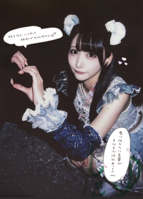 A photograph of a smiling woman in a blue frilly dress and hair accessories is decorated with hand-drawn heart shapes and Japanese text in speech bubbles, resembling a manga layout.