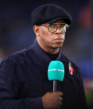 Ian Wright, seen here holding a BBC Sport microphone while wearing a black flat cap and glasses, appears visibly somber as he comments on Manchester City's charges, suggesting that their upcoming match against Liverpool may remind them of the toll their dominance took on Klopp's team.