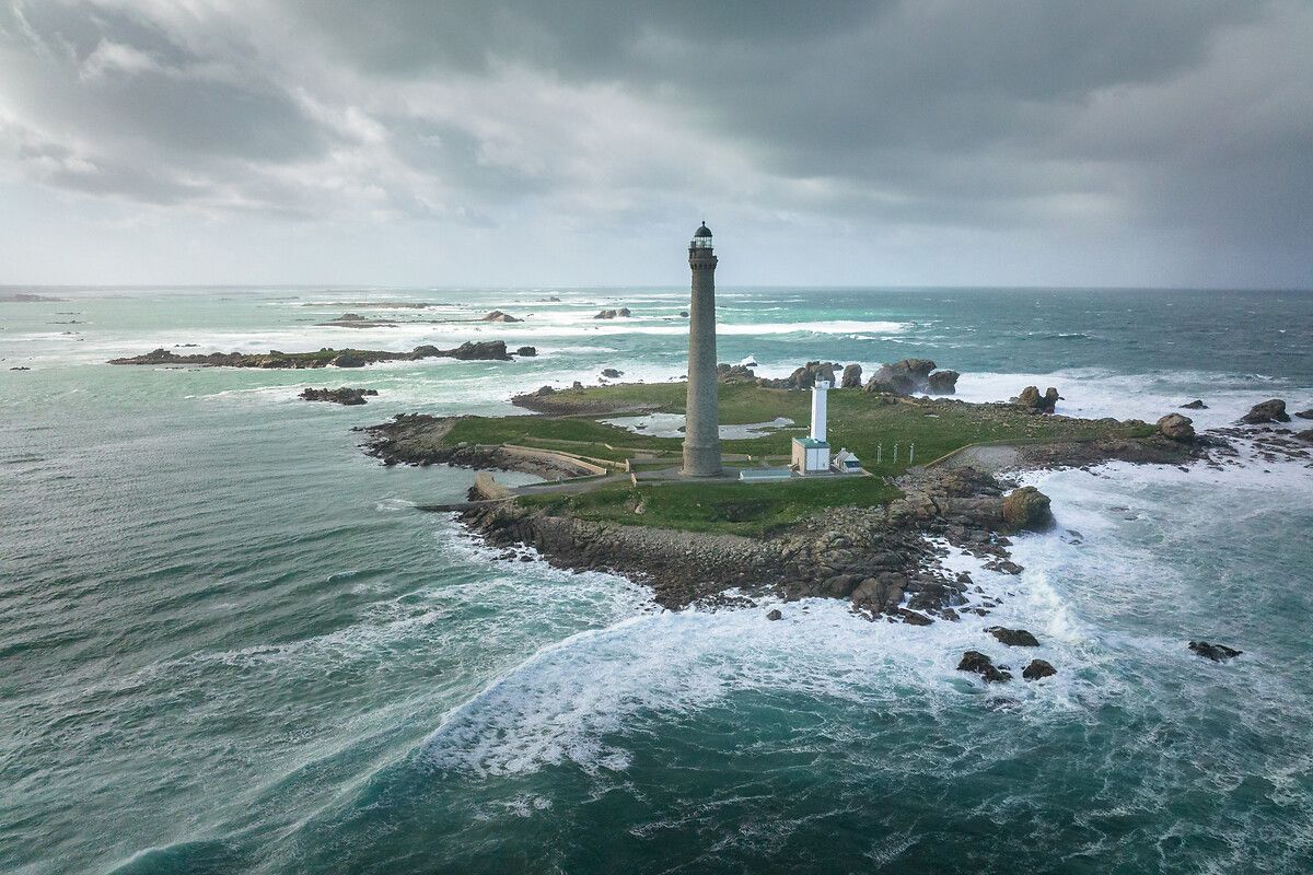 CeJourHistoire's tweet photo. Le plus haut phare de pierre du monde est breton : 82,5 mètres. À l'intérieur, 12 500 plaques de verre tapissent l'escalier, et personne ne les a posées pour faire joli.

C'est le phare de l'Île Vierge, planté sur un îlot face à Plouguerneau, sur la côte nord du Finistère.

Ici passent les navires qui entrent dans la Manche. La côte est hérissée de récifs.

Un premier phare veillait déjà sur l'îlot depuis 1845. Une tour carrée d'une trentaine de mètres.

Sa lumière ne portait pas assez loin.

En 1897, l'État décide d'en bâtir un second, juste à côté. Il est allumé le 1er mars 1902.

L'ancien n'a pas été démoli. Les deux tours se tiennent encore côte à côte, la petite et la géante.

Pour atteindre la salle de veille, il faut gravir 365 marches. Une par jour de l'année.

Les plaques sont en opaline, un verre laiteux fabriqué par Saint-Gobain. 900 mètres carrés au total.

La raison est pratique. Sur un rocher en pleine mer, la condensation attaque la pierre, et l'opaline était alors le meilleur moyen connu pour la combattre.

Pendant plus d'un siècle, des gardiens ont monté ces marches chaque nuit.

Les derniers sont partis le 29 octobre 2010. Le phare est désormais piloté à distance, depuis le phare du Créac'h, à Ouessant.

Il est classé monument historique depuis 2011.

Toutes les 5 secondes, un éclat blanc balaie encore la mer. Les marins qui le guettent ne verront jamais ses 12 500 plaques de verre.

Quel phare de France vous a le plus impressionné ?