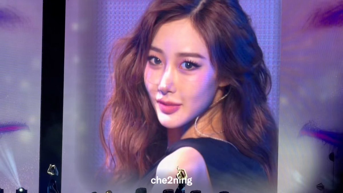A large concert screen displays a close-up portrait of a woman with wavy brown hair and glamorous makeup, with the text "che2ning" overlaid at the bottom.
