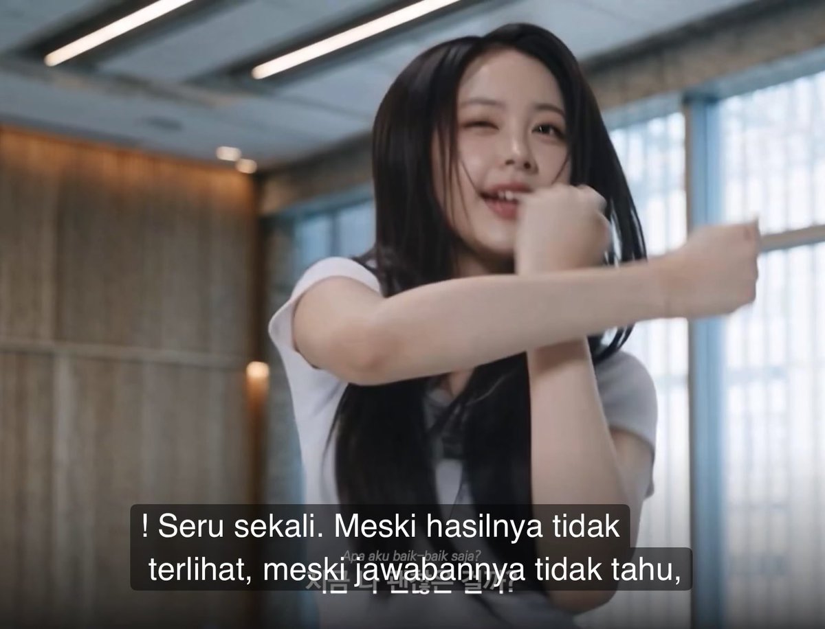 A young woman with long dark hair winks and smiles while moving her arms playfully, with Indonesian subtitles reading '! Seru sekali. Meskipun hasilnya tidak terlihat, meskipun jawabannya tidak tahu,' overlaid on the image.