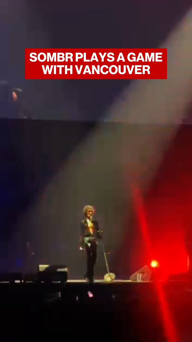 A vertical video frame showing a performer on a stage with a red banner overlay reading 'SOMBR PLAYS A GAME WITH VANCOUVER'.