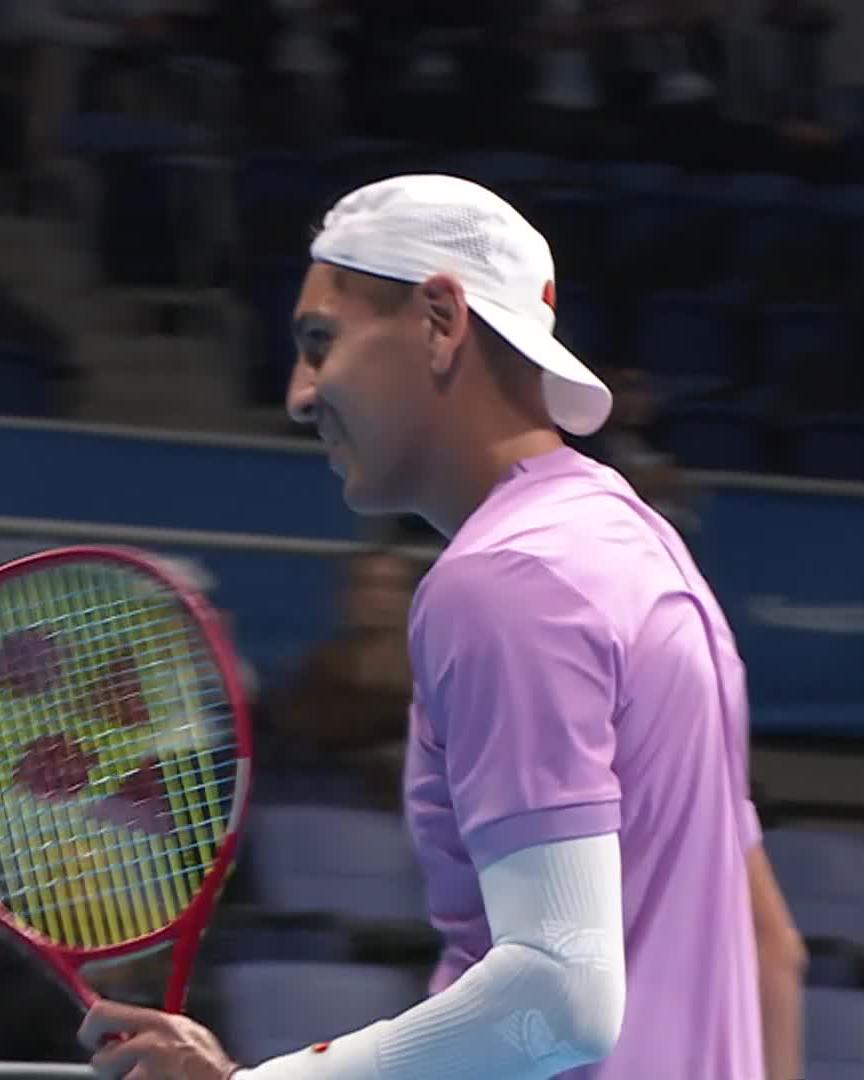 Alejandro Tabilo, dressed in a lavender shirt, white backward cap, and white arm sleeve, holds a red Yonex racket on the court after delivering a dominant 6-1, 6-2 upset win over Tommy Paul at the Japan Open tennis tournament.