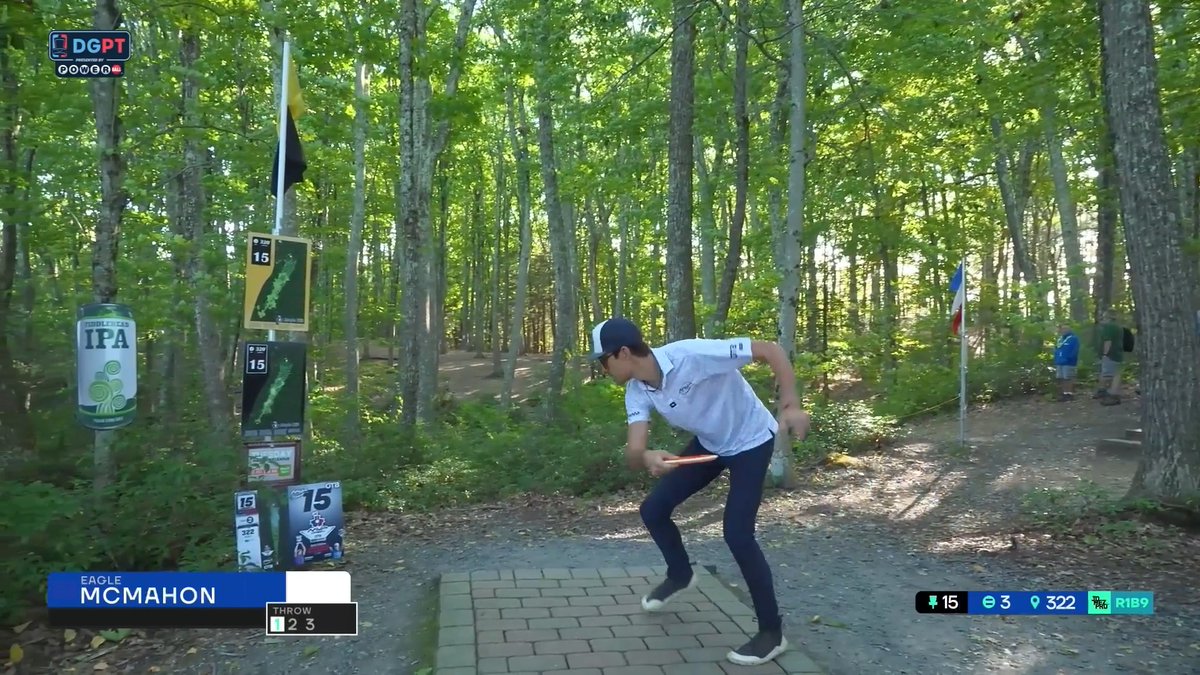 A disc golf player named Eagle McMahon throws a disc from a tee pad on Hole 15 in a wooded course, with broadcast graphics showing par 3, 322 feet, and DGPT branding.