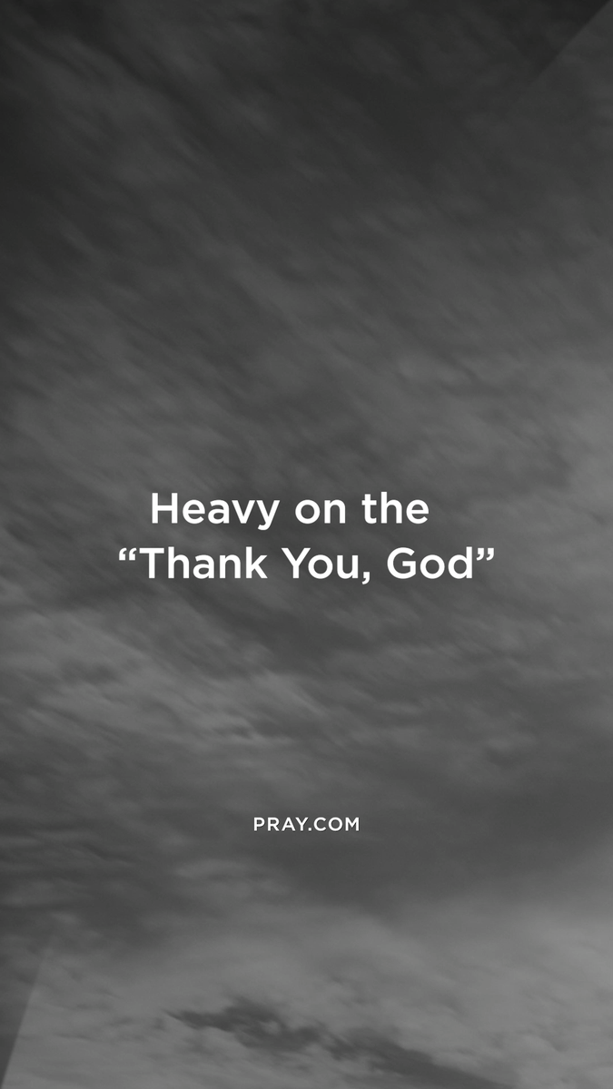 A grayscale image of a cloudy sky with the text "Heavy on the 'Thank You, God'" and "PRAY.COM" overlaid in white.