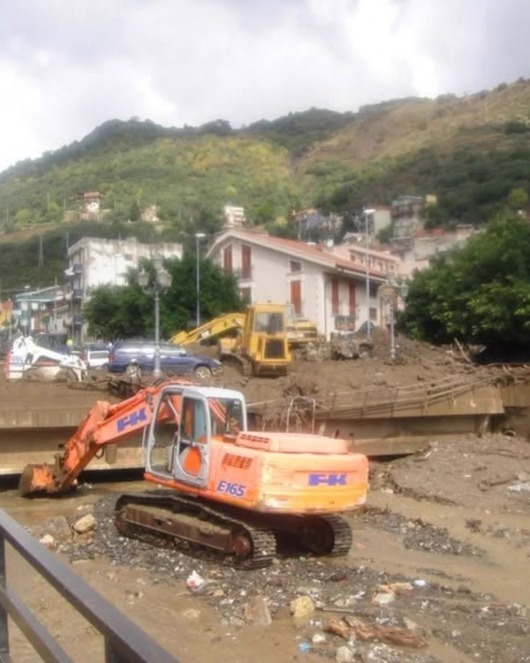 Scavatori e mezzi pesanti al lavoro per rimuovere il fango.