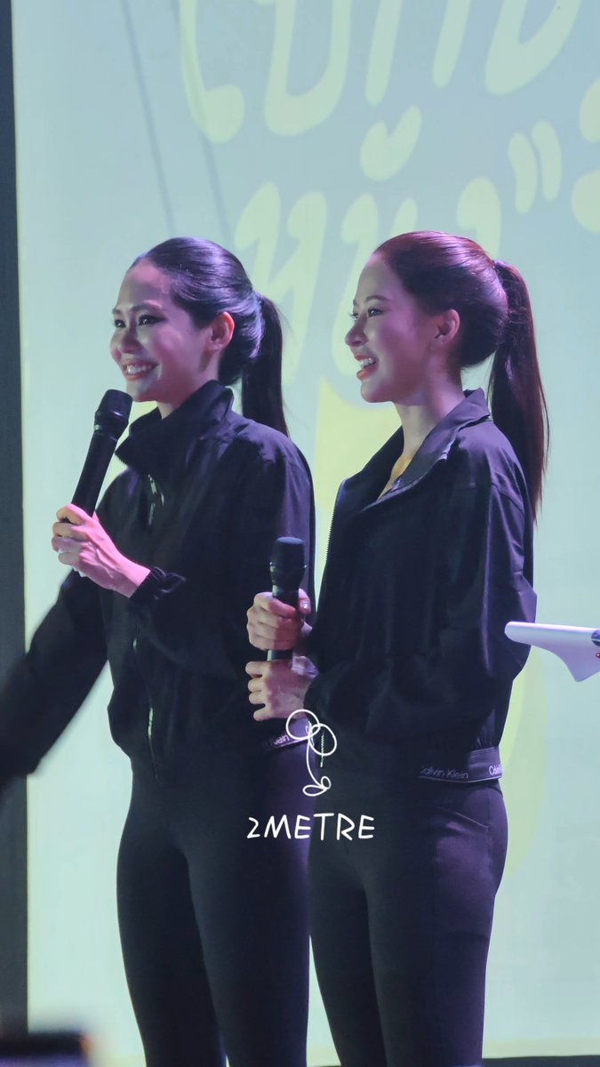 Two performers, identified as Puinoon and Bint, smile while holding microphones on stage at the "MOVE TOGETHER" fan event, with a "2METRE" watermark visible on the image.