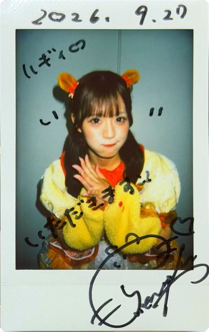 A Polaroid-style photo dated "2026.9.27" shows a young woman in a yellow and orange outfit with bear-ear hair accessories, featuring Japanese handwritten text and a signature on the borders.