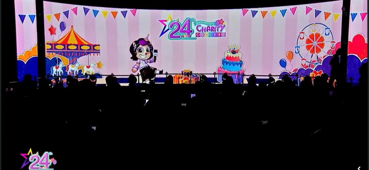 A live concert stage with a large screen displaying '24th Anniversary Charity Concert' featuring a chibi character, circus, cake, and ferris wheel illustrations.