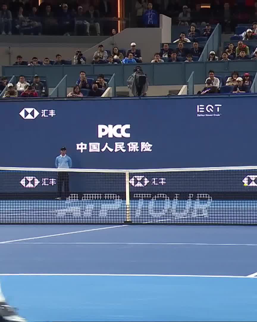 Djokovic takes an early break against Borges at the China Open, as seen on the blue hard court with visible "PICC 中国人民保险" and "汇丰" sponsor banners behind the net.