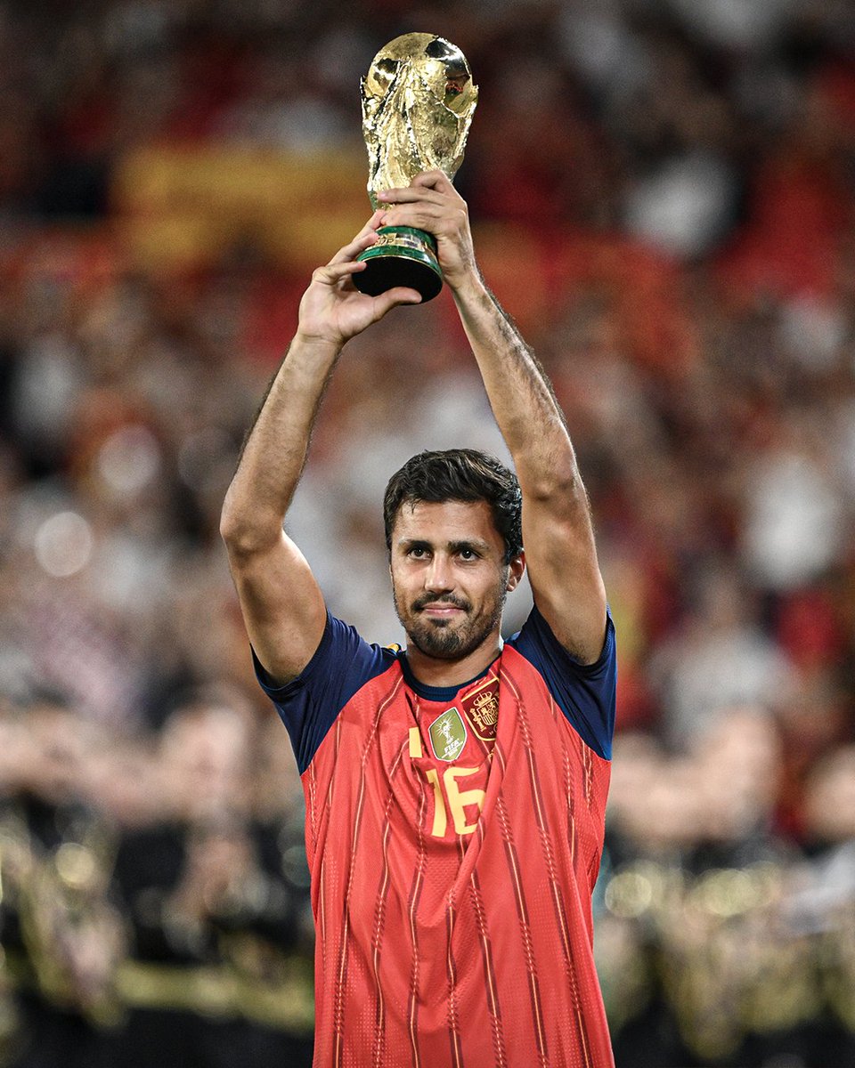 LesleyBallpc's tweet photo. Rodri presented the World Cup trophy at the Estadio Ramón Sánchez Pizjuán in front of Spain fans prior to their match vs. Croatia 🏆 https://t.co/7Rp5OnWADM